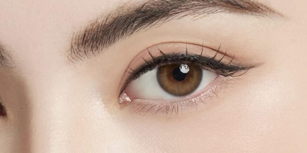 Lollipop Warm Brown colored contacts on dark eyes showing soft caramel-brown coverage with natural warmth and approachable finish