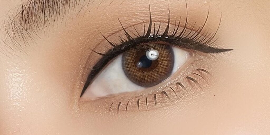 Glamlens No.1 Hazel colored contacts on dark eyes showing multi-tonal amber-green hazel with light-reactive pigment for natural depth
