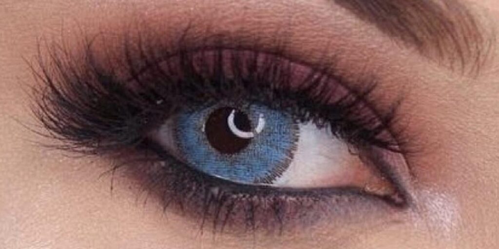 Dreamcolor Teresa Blue monthly colored contacts on dark eyes showing true cornflower blue with natural texture pattern and defined limbal ring