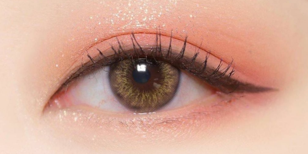 Sisse Babe Apricot Daily colored contacts on dark eyes showing warm peachy-bronze tone with soft natural coverage for daily disposable wear
